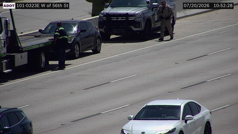 Tow truck and police vehicle assisting a car on the right shoulder