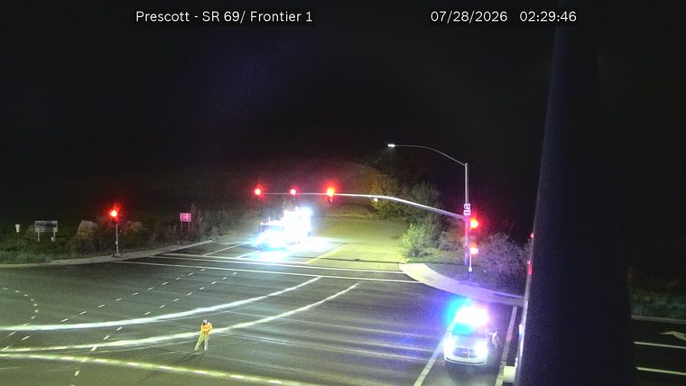 Police car with blue and red lights on the right side of the intersection
