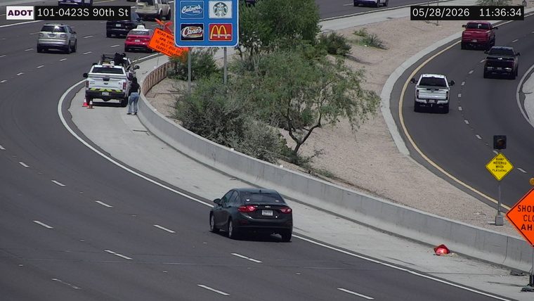 Construction cones and a worker on the shoulder