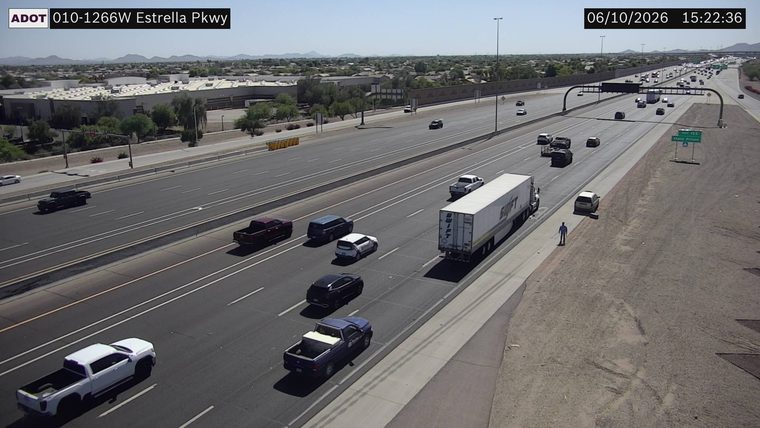 Person standing on the shoulder near a white trailer truck