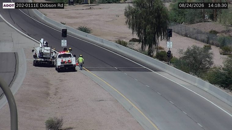 Two workers and two service vehicles on the right shoulder