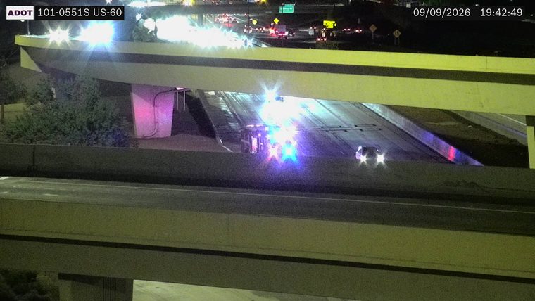 Multiple emergency vehicles with red and blue lights active in the roadway