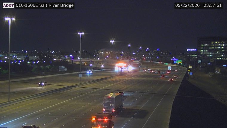 Multiple emergency vehicles with red and blue lights active in the left lanes