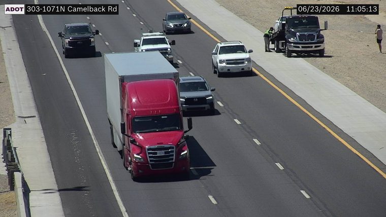 Tow truck assisting a vehicle on the right shoulder