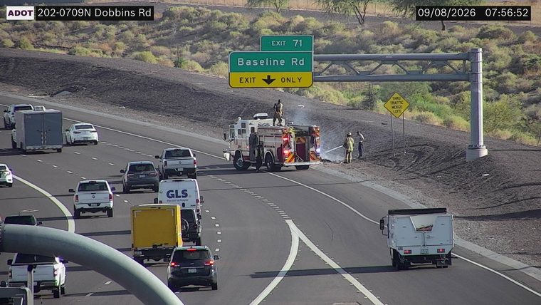Fire truck and firefighters on the right shoulder with smoke and flames visible