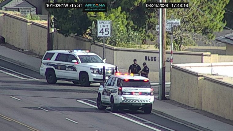 Two police vehicles and two officers on the roadway