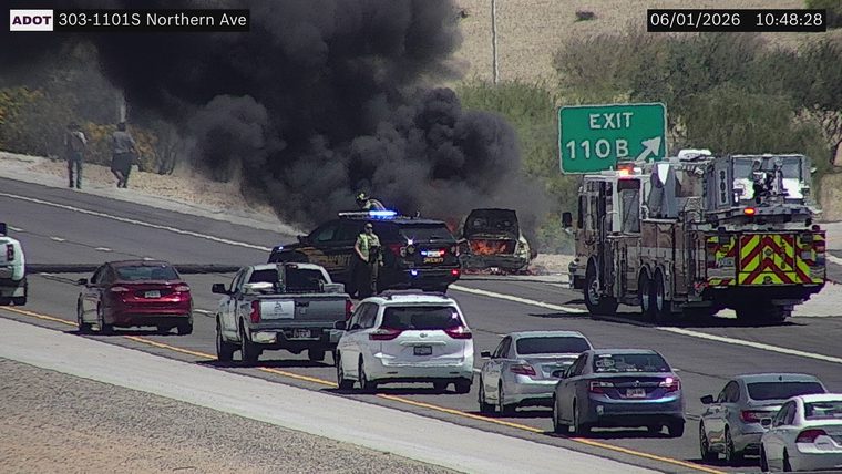 Burning vehicle with responders and fire truck in the right lane