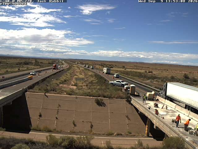 Construction workers and equipment on the right side of the roadway