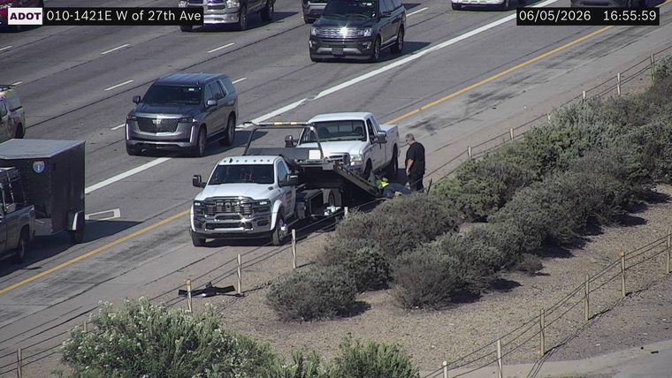 Tow truck assisting a person on the right shoulder
