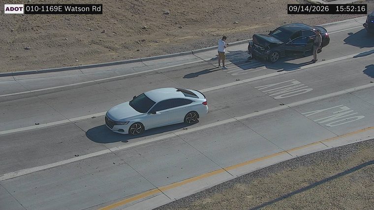 Black sedan with visible front-end damage and open driver door in the left lane