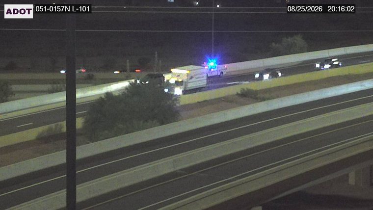 White truck with blue flashing lights on the right shoulder