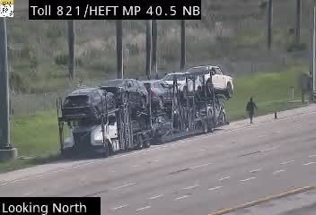 Car carrier appears to have lost some vehicles, creating debris on the roadway.