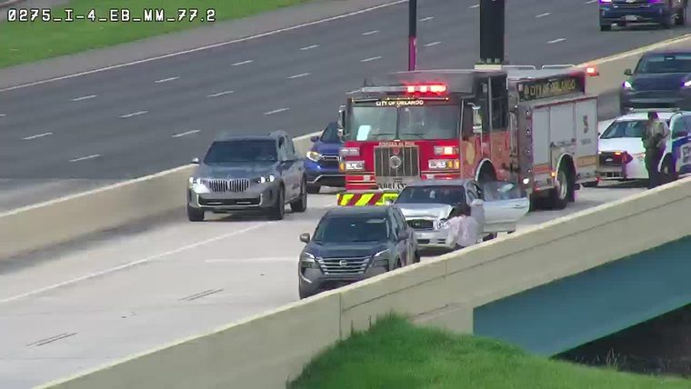 Fire truck with red lights on and police car on the right shoulder