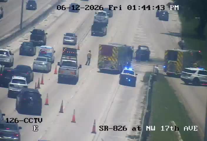 Emergency responders and vehicles on the roadway with traffic cones present.