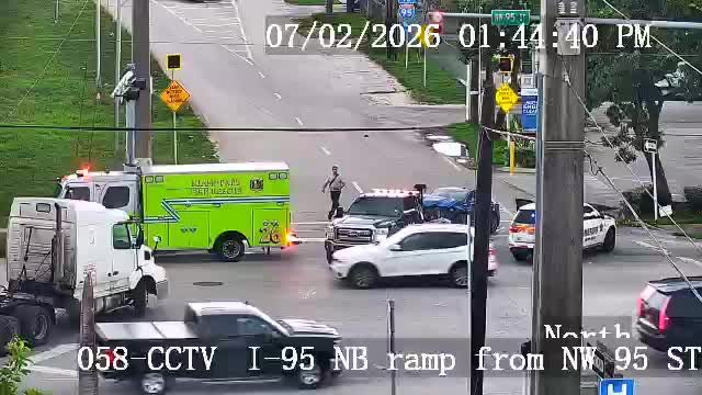 Ambulance and police car with lights on at intersection
