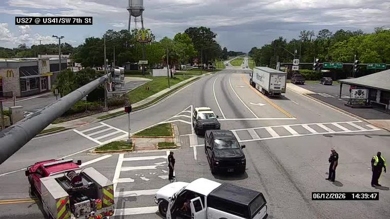 Police officers and a fire truck are present at a roadside incident.