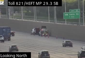 Emergency responders are on scene with vehicles and cones on the highway.
