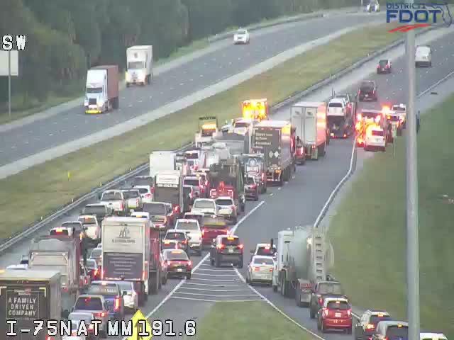 Multiple vehicles with flashing lights in the right lanes