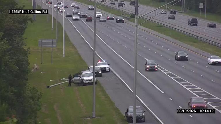 Police cars and personnel on the roadside near a downed pole.