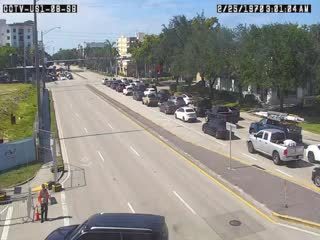 Emergency responders and vehicles are present on the roadside, directing traffic.