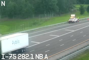 Two workers and a truck are on the shoulder of I-75 near mile marker 282.1.