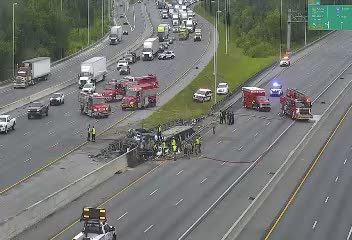Multiple emergency vehicles and personnel at a vehicle accident scene on the highway.