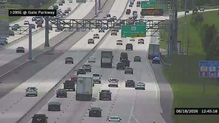 Police car with flashing lights on the highway shoulder.