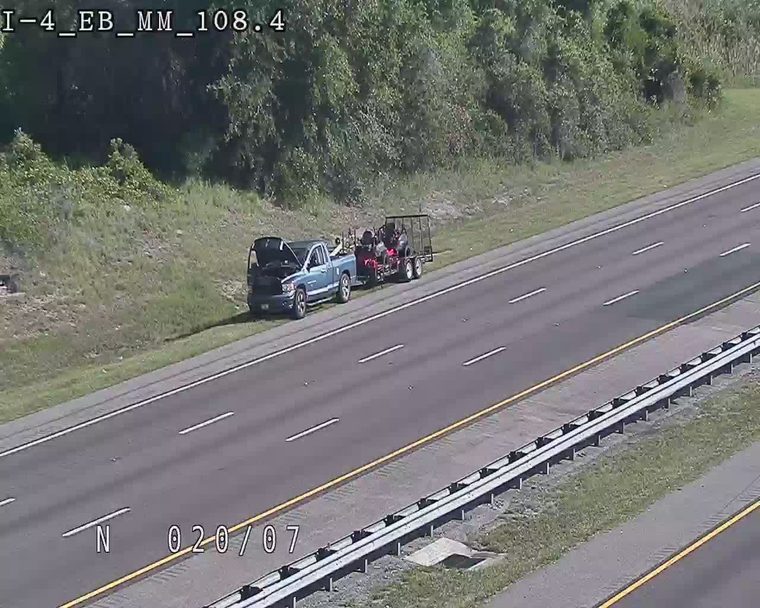 Truck with hood open and trailer on shoulder, possibly a breakdown or responder scene.