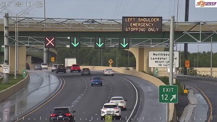 Emergency vehicle on shoulder with flashing lights, traffic diverted.