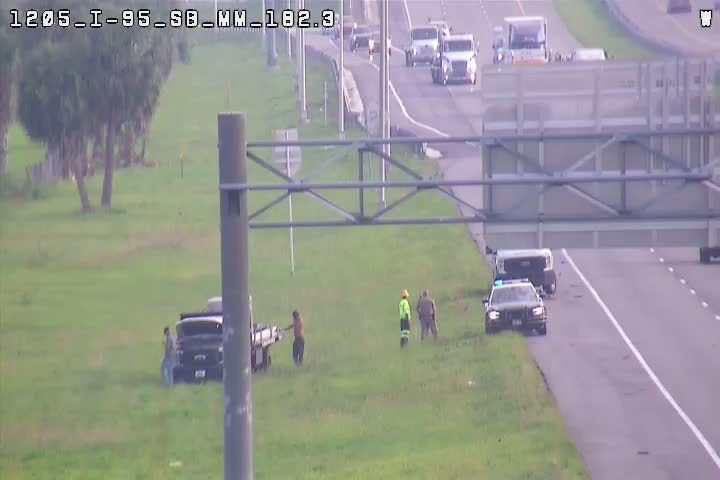 Police and workers are on the scene of a roadside incident with a truck.