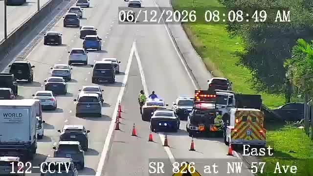 Emergency responders and tow truck on scene with traffic cones on the highway.