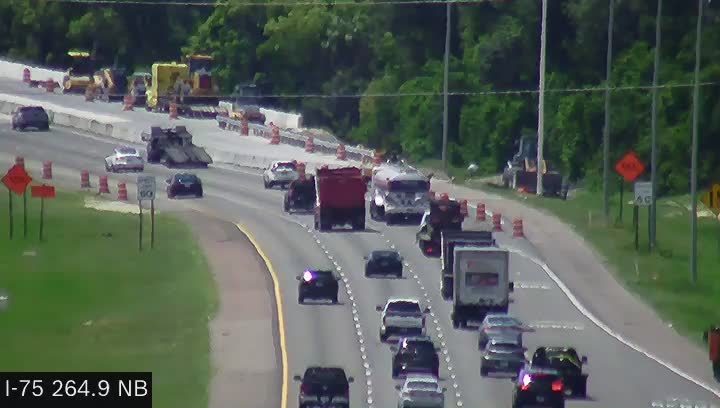 Police car with flashing lights on the highway, traffic moving around it