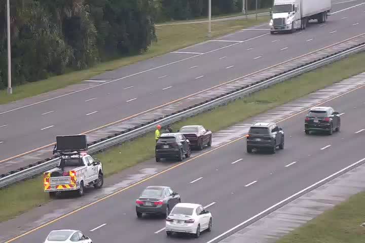 Road crew with truck and personnel on the shoulder of the highway.