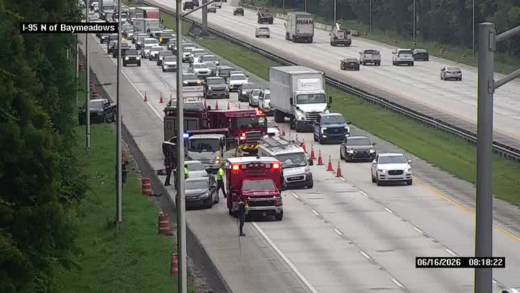 Emergency responders and vehicles are present on the highway, indicating an incident.