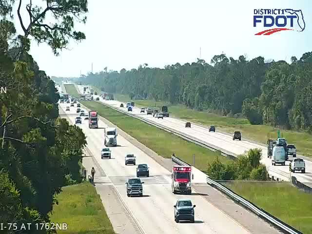 Ambulance and other vehicles on the side of the highway.