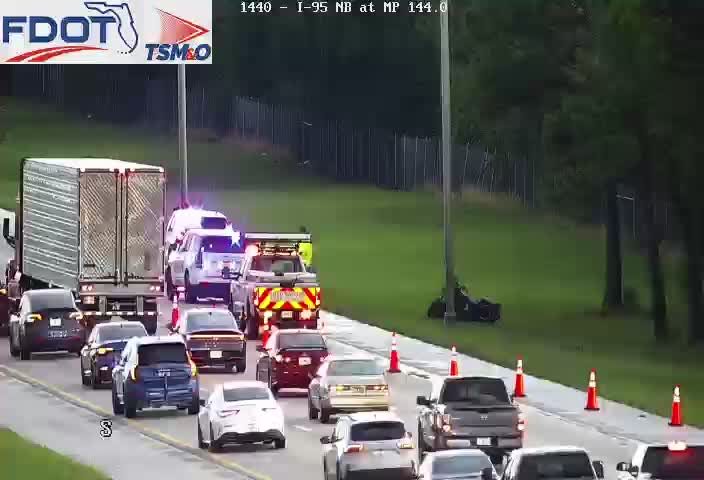 Tow truck with flashing lights and a police car with flashing lights in the right lane