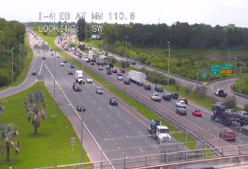 Tow truck and responders attending to a vehicle on the right shoulder of the highway.