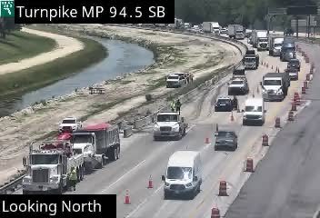 Construction workers and vehicles on the roadway, possibly responding to an incident.