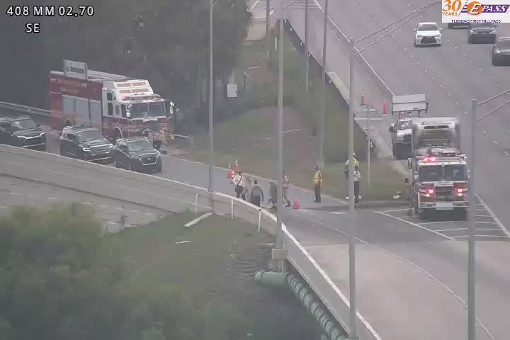 Fire trucks and personnel on the roadside indicate an emergency response situation.