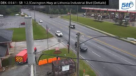 Fire truck and personnel on scene with traffic cones and barriers.