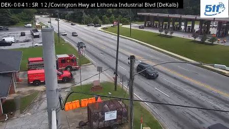 Fire trucks and emergency personnel are on the scene of an incident on the roadway.