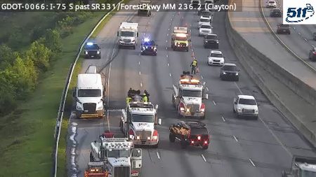 Multiple tow trucks and police cars on the highway, indicating an incident response.