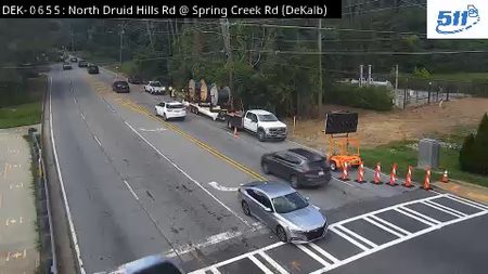 Traffic cones and a portable sign indicate a possible road closure or work zone.