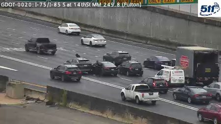 Police officers are attending to a stopped vehicle on the highway.