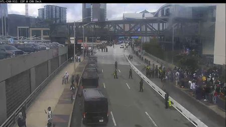 Police officers and crowd gathered on the roadside, blocking traffic.