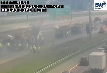Emergency responders and vehicles are present on the roadway, indicating an incident.
