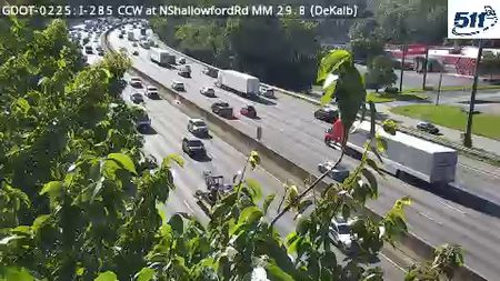 Emergency vehicle and tow truck on the side of the highway, traffic is moving.