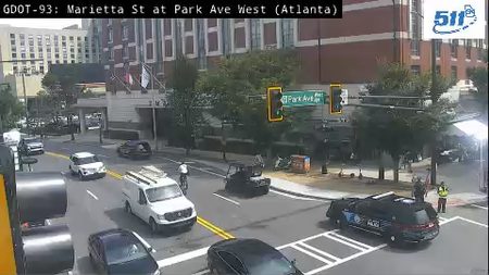 Police car and officer present at intersection, directing traffic.