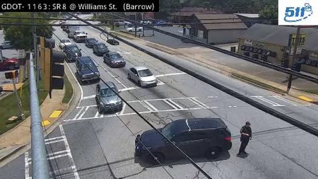 Police officer directing traffic at an intersection with a stopped vehicle.