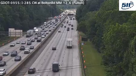 Emergency responders and cones on the right shoulder of the highway.
